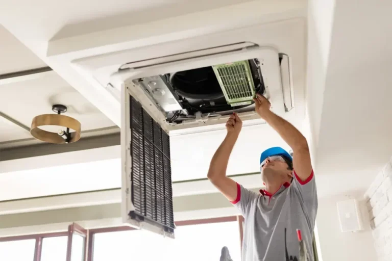 Technician repairing air conditioner in Dubai home