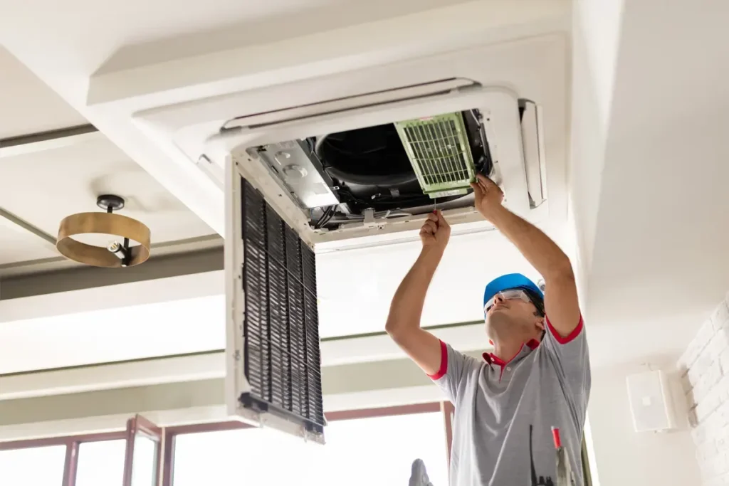 Technician repairing air conditioner in Dubai home